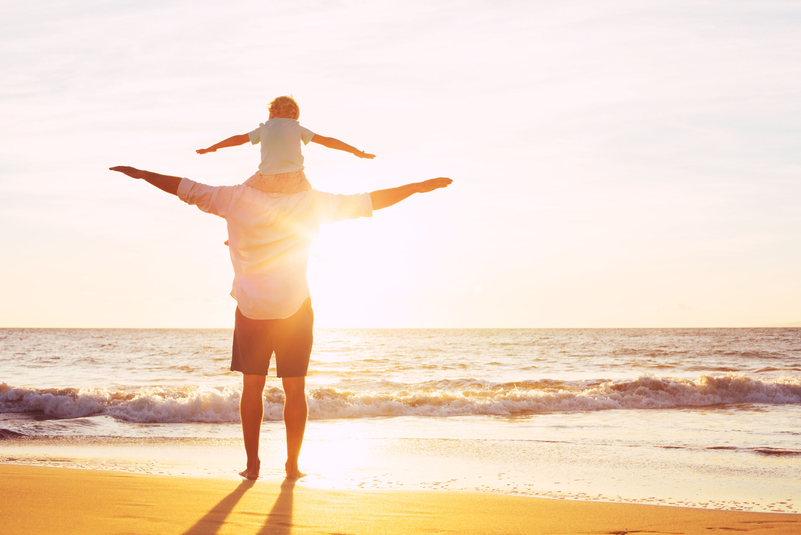 Father,And,Son,Playing,On,The,Beach,At,Sunset,,Having